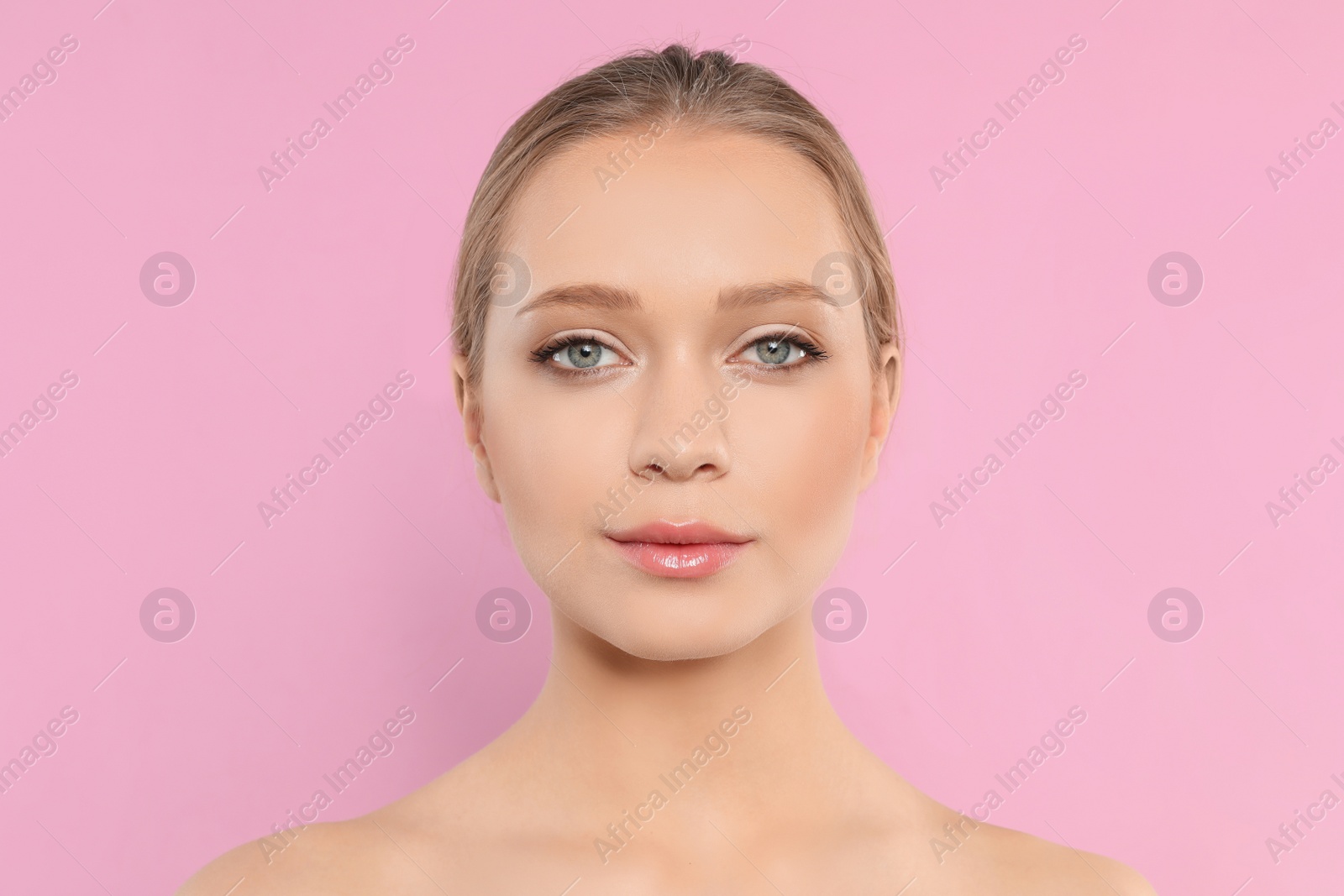 Photo of Portrait of young woman with beautiful face on pink background