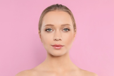 Portrait of young woman with beautiful face on pink background