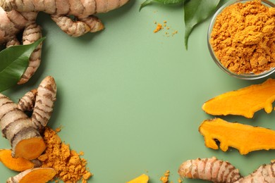 Photo of Frame of aromatic turmeric powder, raw roots and leaves on green background, flat lay. Space for text