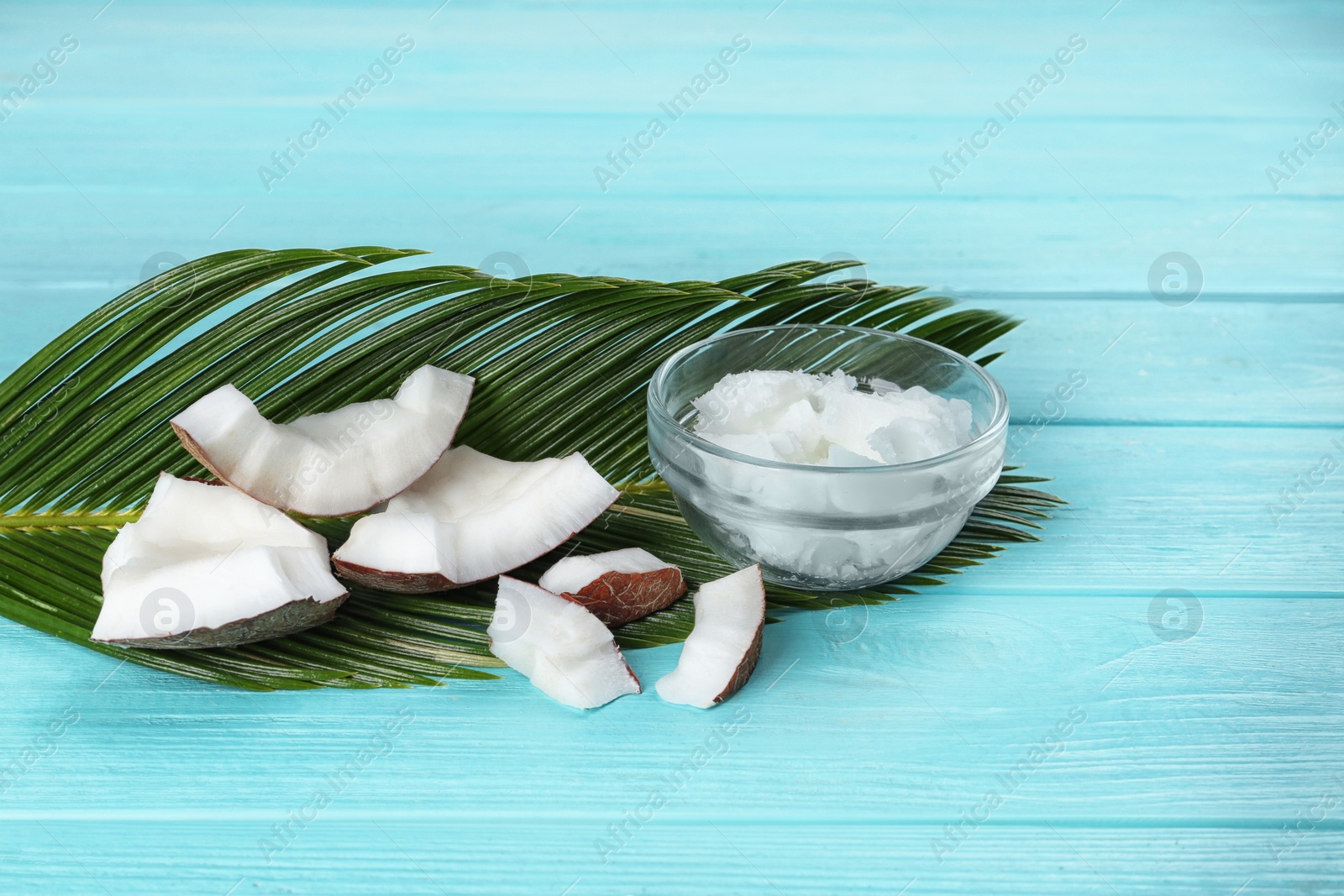 Photo of Composition with organic coconut oil on light blue wooden table. Healthy cooking