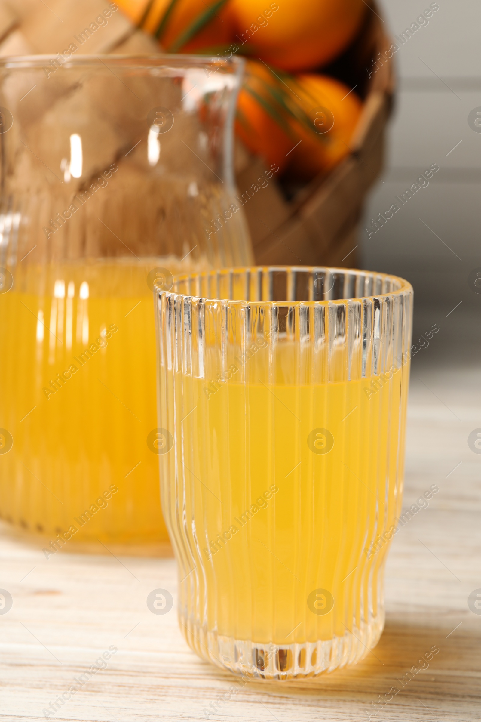 Photo of Tasty freshly made orange juice on white wooden table