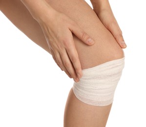 Photo of Woman with knee wrapped in medical bandage on white background, closeup