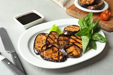 Plate with fried eggplant slices on table