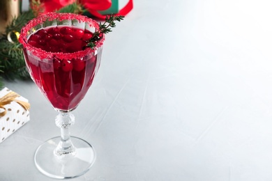 Photo of Delicious Christmas cocktail with liqueur on light table. Space for text