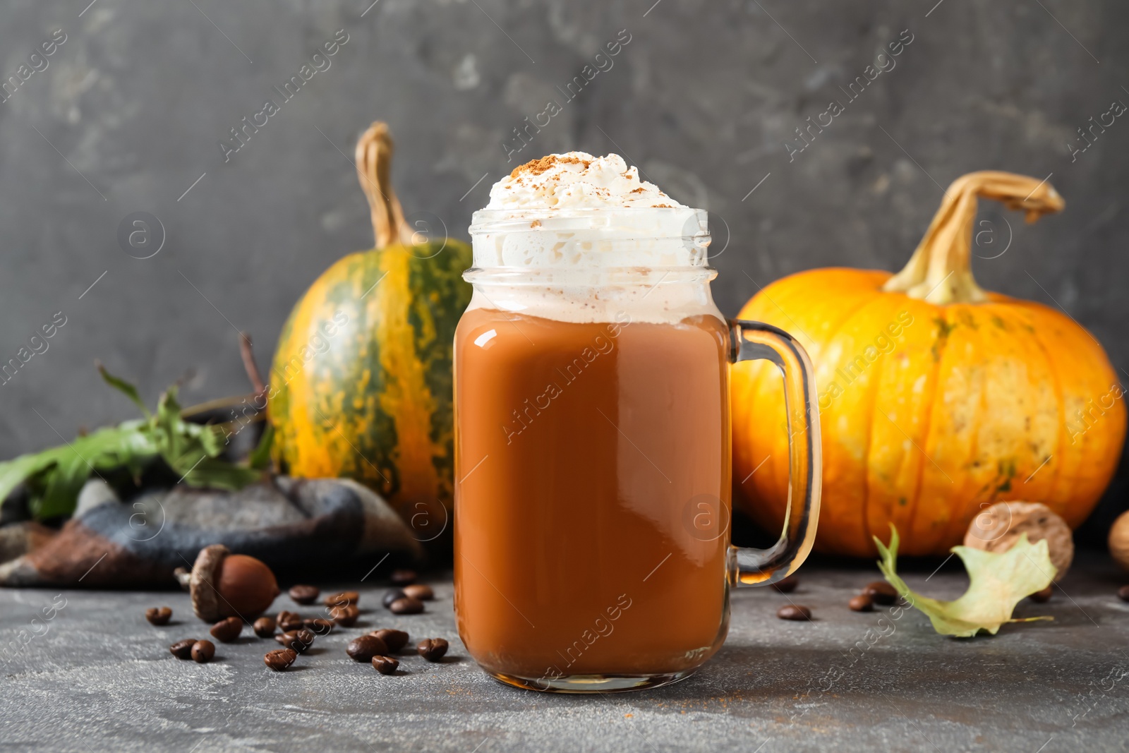 Photo of Mason jar with tasty pumpkin spice latte on grey table