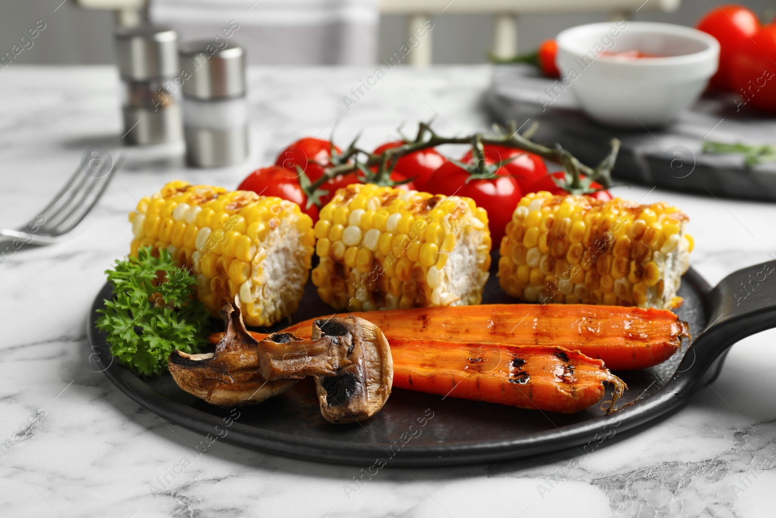 Photo of Delicious grilled vegetables served on white marble table, closeup