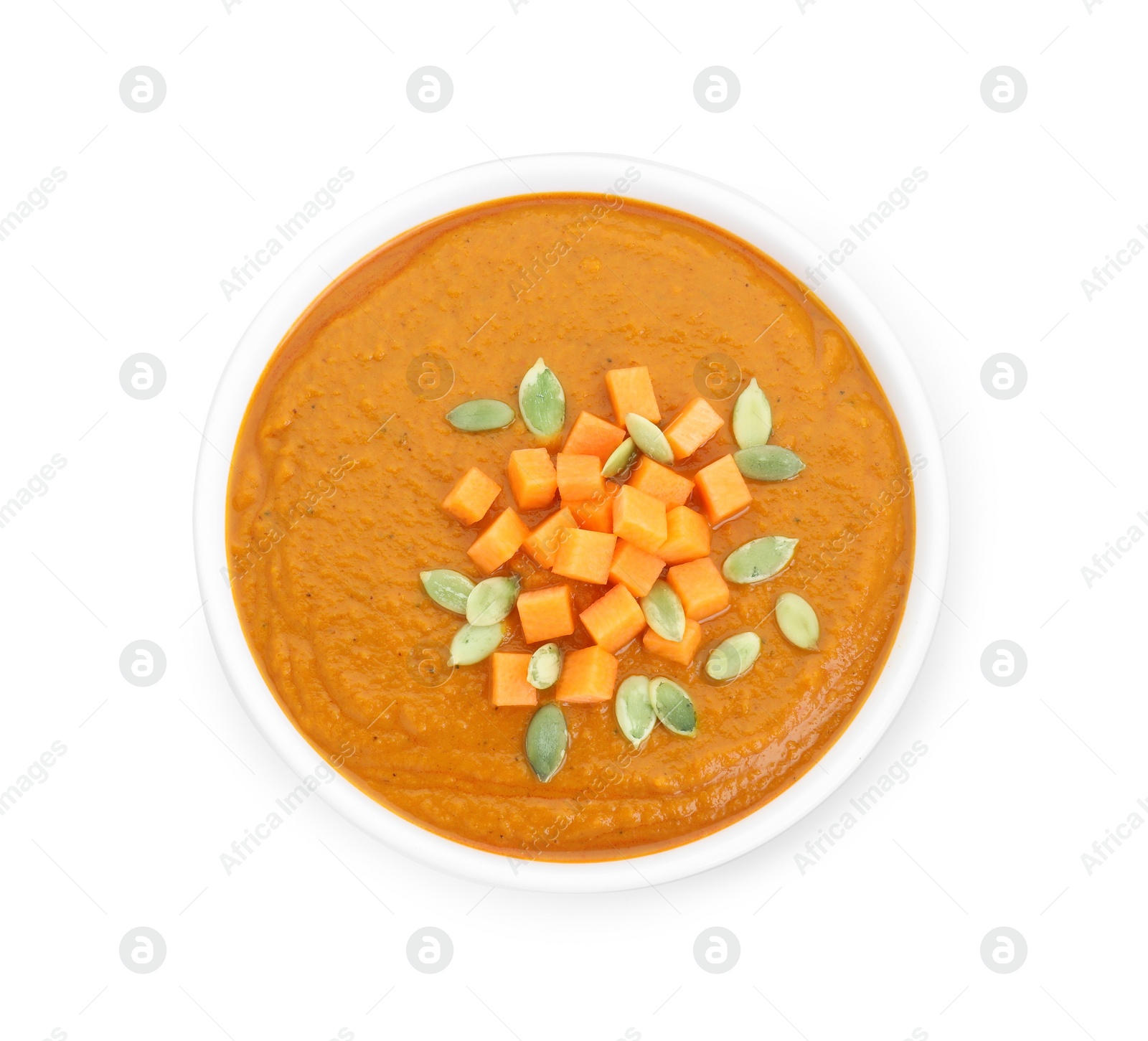 Photo of Delicious pumpkin cream soup with seeds in bowl isolated on white, top view