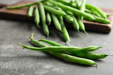 Photo of Fresh green beans on grey table, closeup