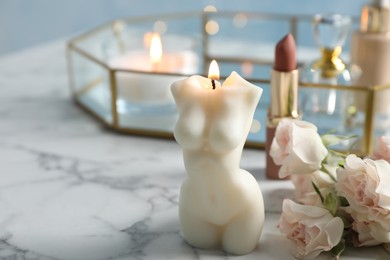 Photo of Beautiful female body shaped candle on white marble table. Space for text