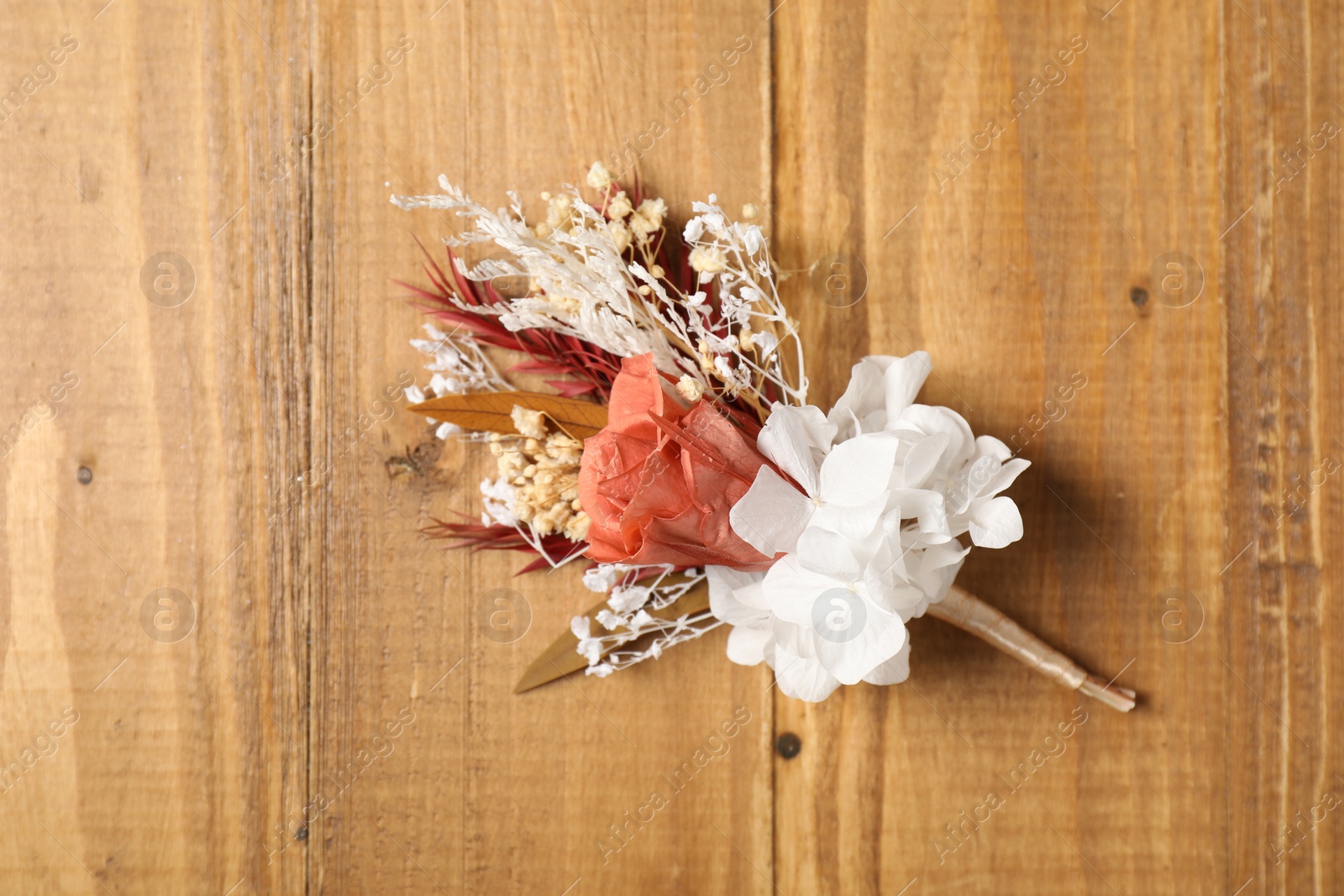 Photo of Stylish boutonniere on wooden table, top view