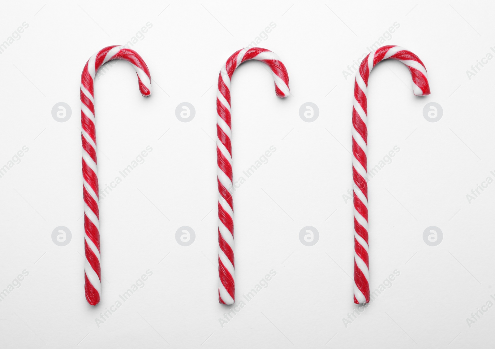 Photo of Many sweet Christmas candy canes on white background, flat lay