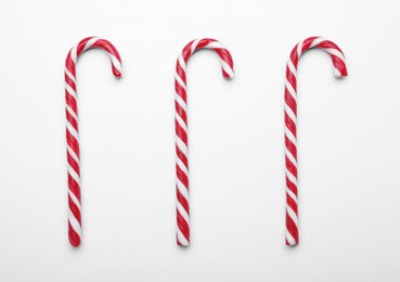 Photo of Many sweet Christmas candy canes on white background, flat lay