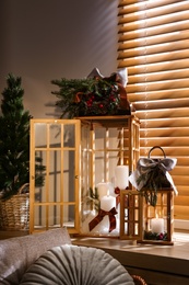Photo of Beautiful Christmas lanterns on windowsill in decorated room