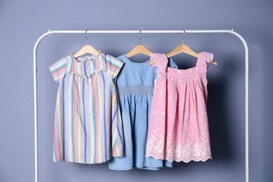 Photo of Rack with stylish child clothes on color background