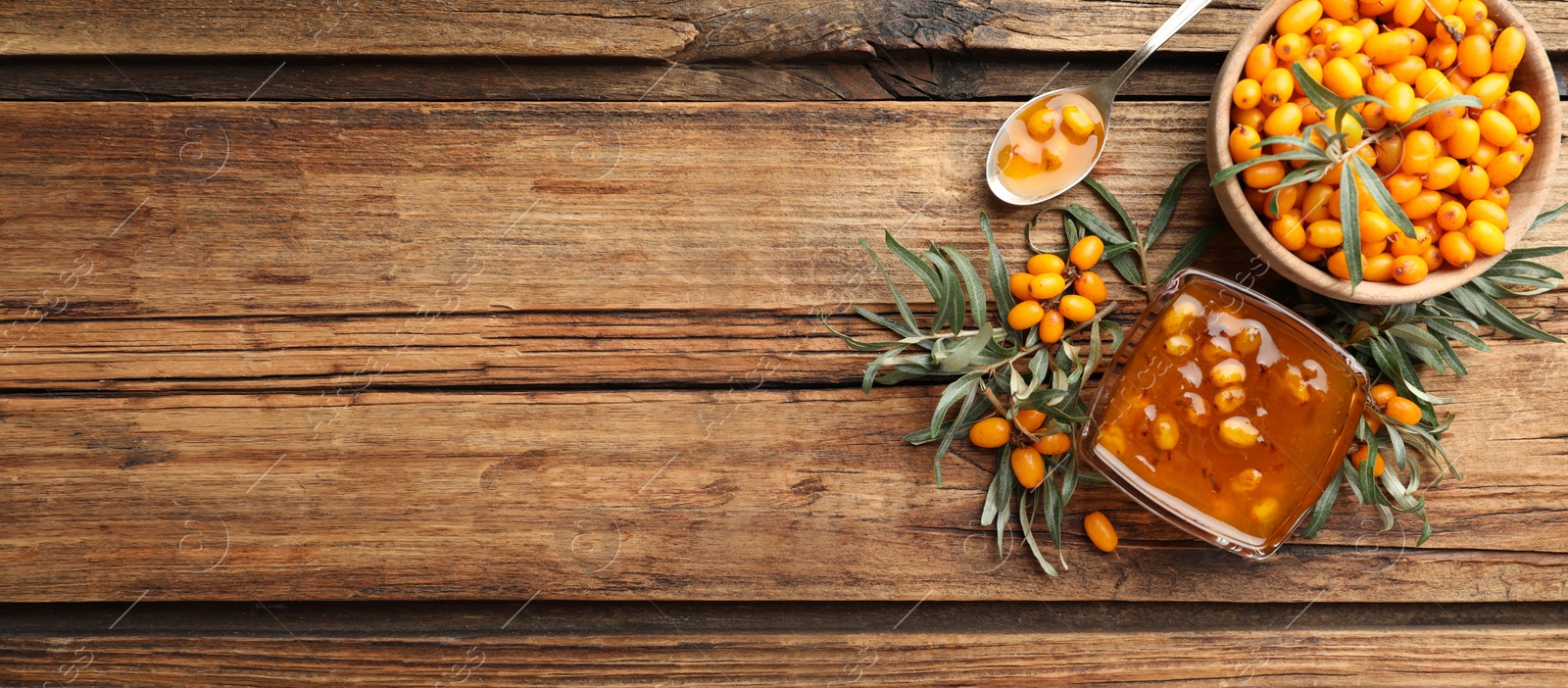 Image of Delicious sea buckthorn jam and fresh berries on wooden table, flat lay. Banner design with space for text