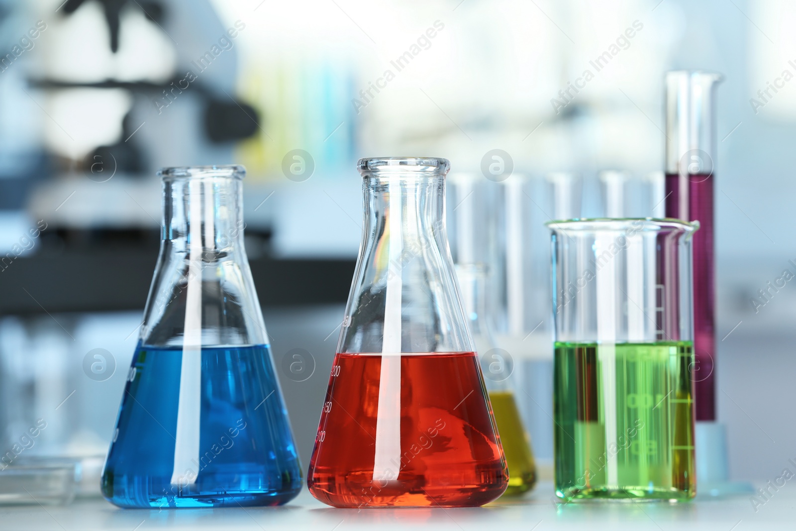 Photo of Glassware with colorful liquids on table in laboratory