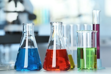 Glassware with colorful liquids on table in laboratory