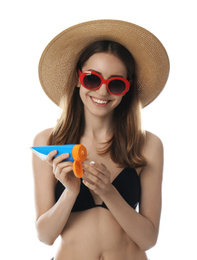 Young woman applying sun protection cream on white background