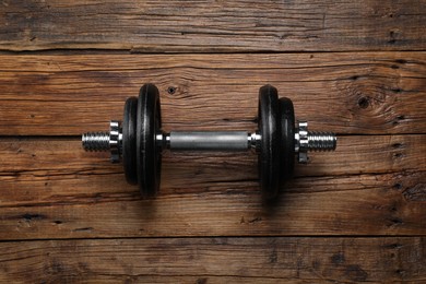 Photo of One barbell on wooden floor, top view