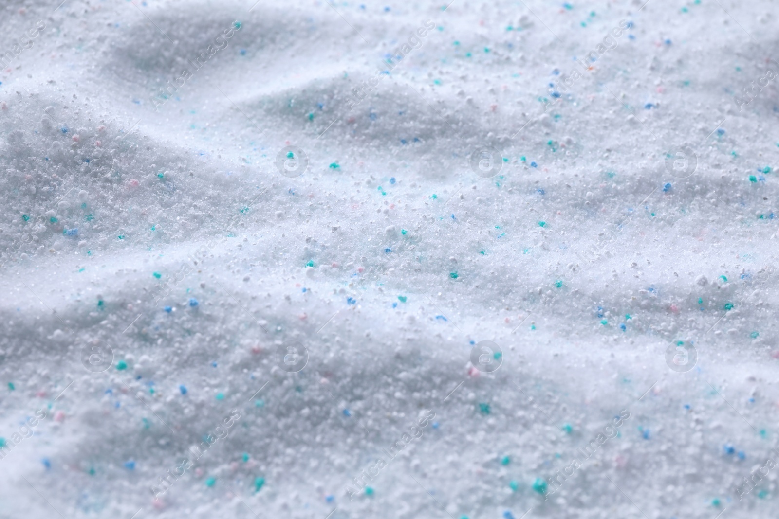 Photo of Laundry powder with color granules as background, closeup