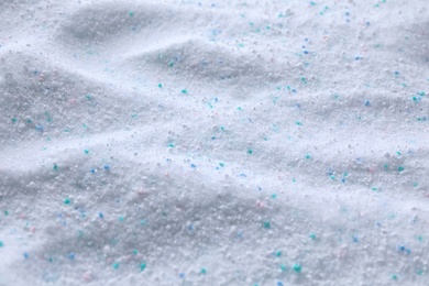 Laundry powder with color granules as background, closeup