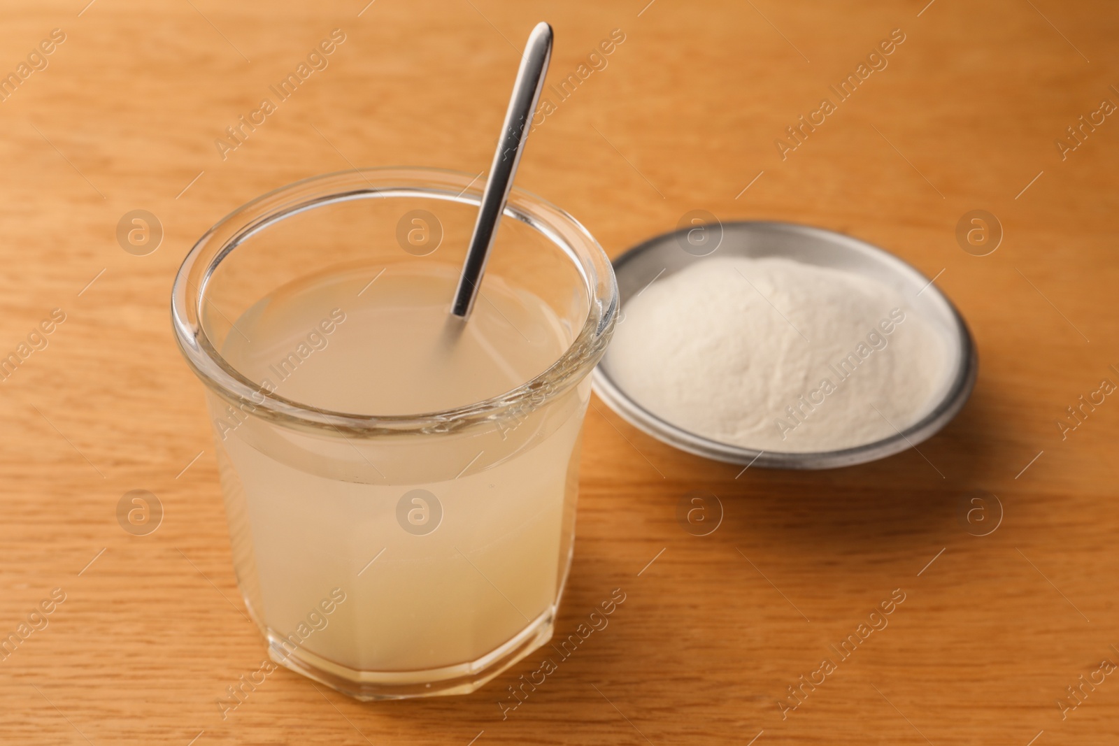 Photo of Agar-agar jelly and powder on wooden table, closeup