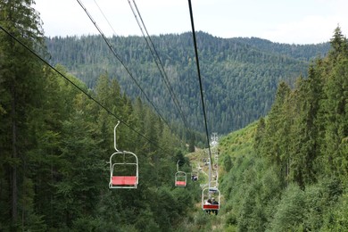 Photo of Ski lift and green trees at mountain resort