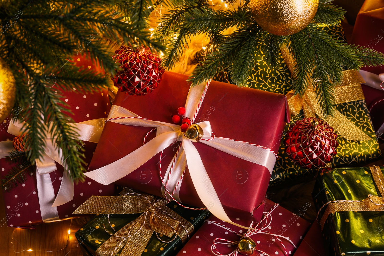 Photo of Pile of gift boxes near decorated Christmas tree