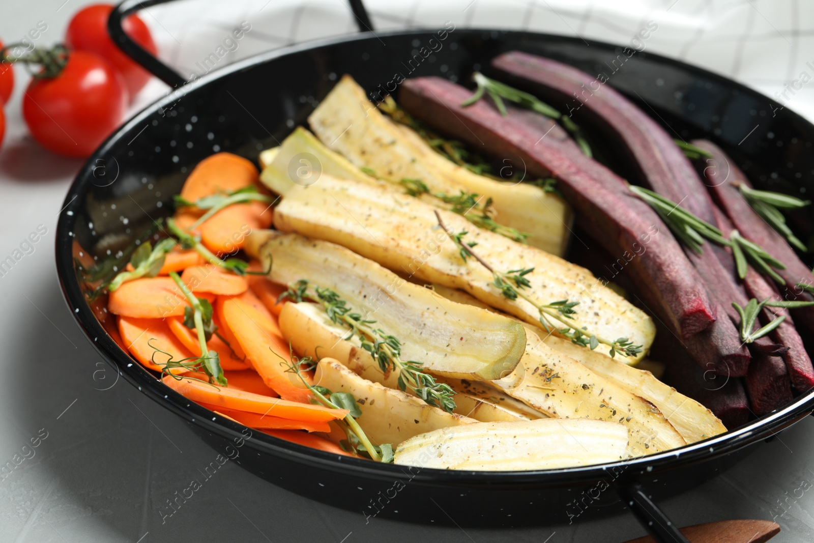 Photo of Raw cut carrots in frying pan on light grey table, closeup