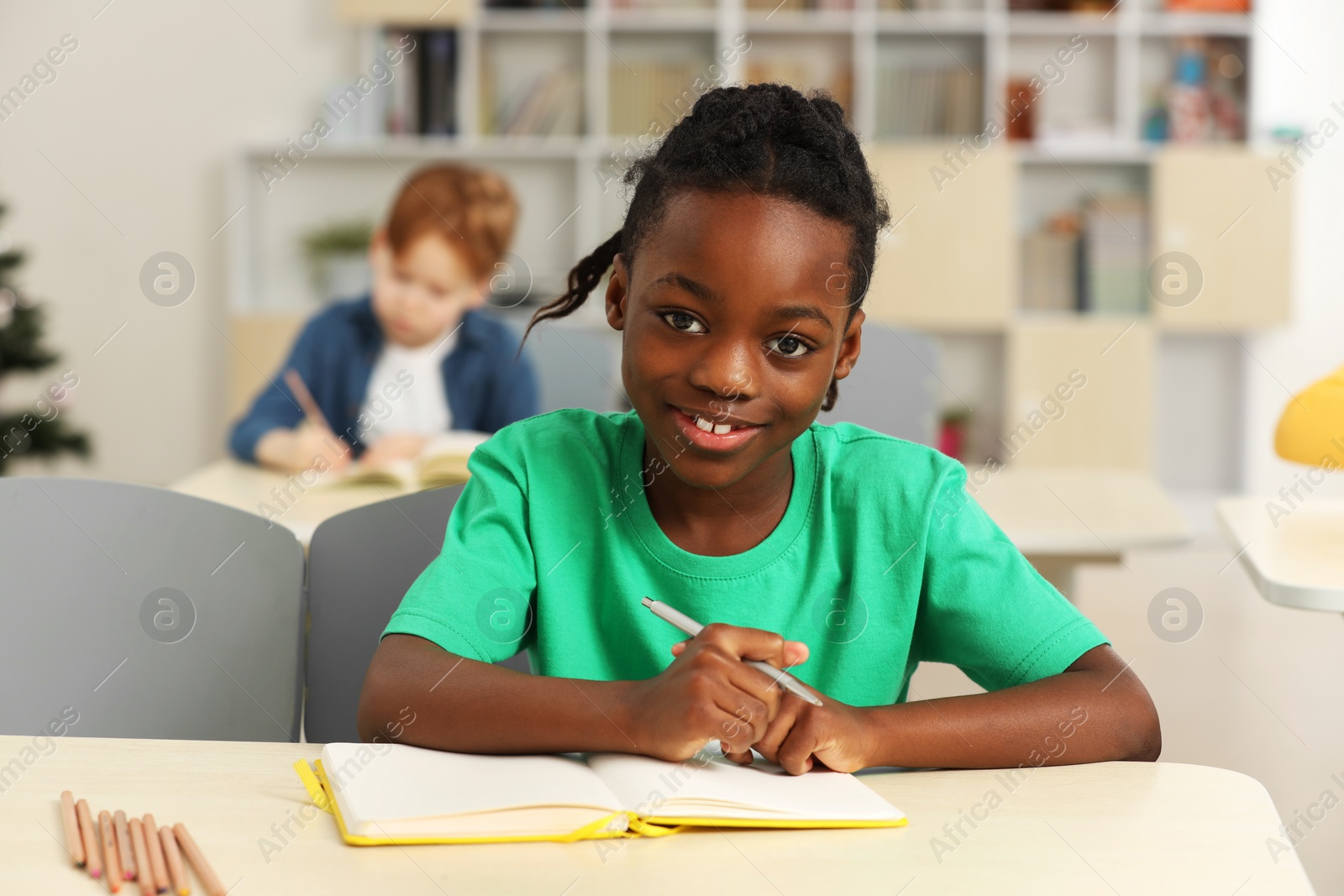 Photo of Portrait of smiling little boy studying in classroom at school