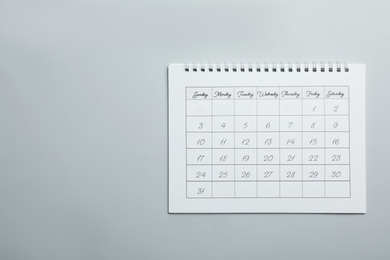 Photo of Paper calendar on light grey background, top view. Space for text