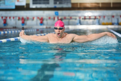 Photo of Young athletic man swimming in pool