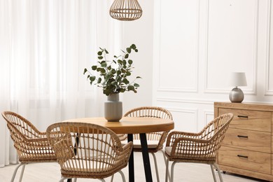 Dining room interior with comfortable furniture and eucalyptus branches