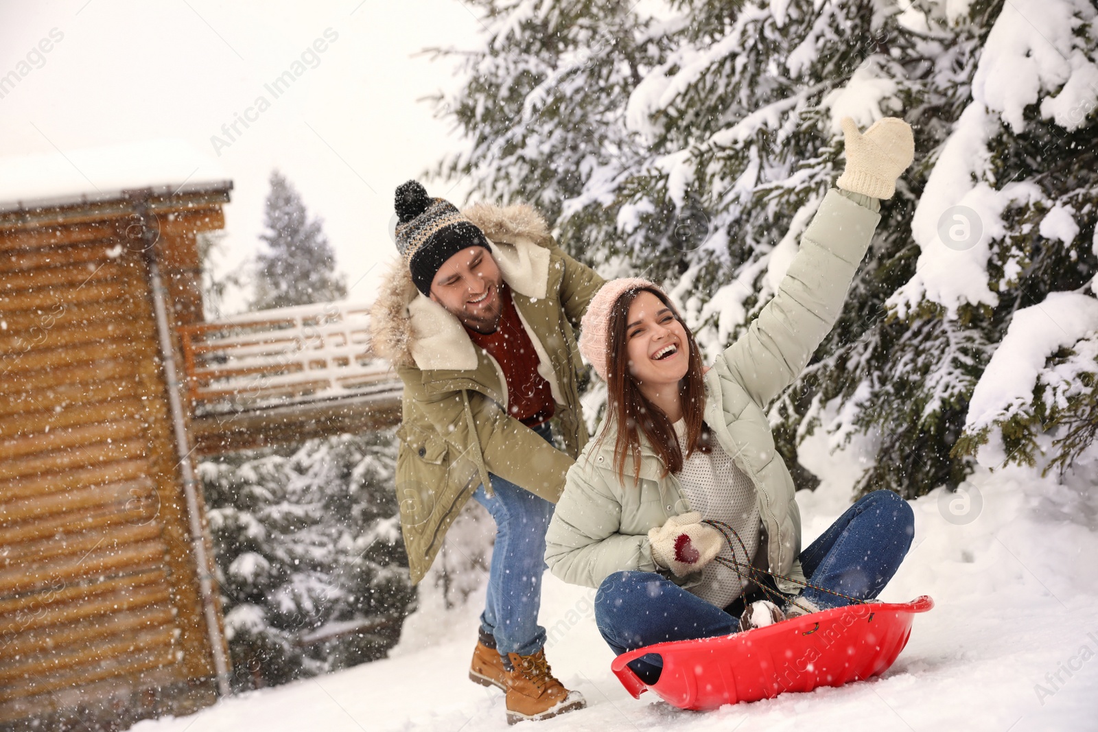 Photo of Couple having fun and sledding on snow. Winter vacation