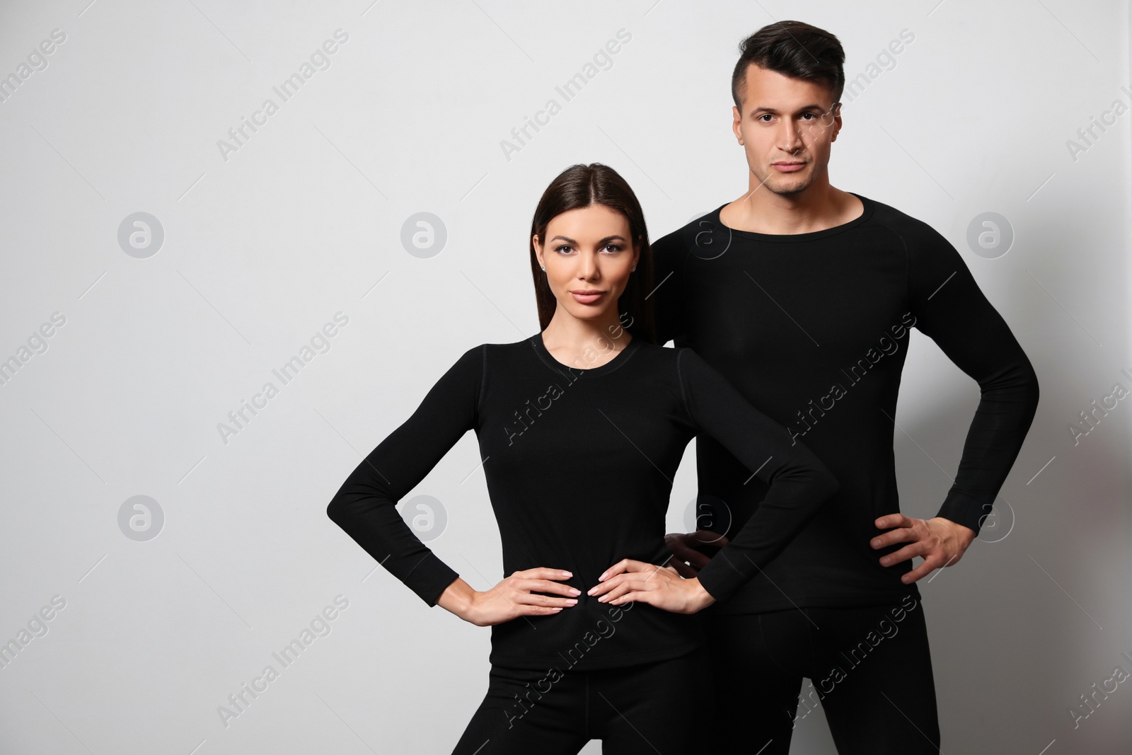 Photo of Couple wearing thermal underwear on light grey background. Space for text