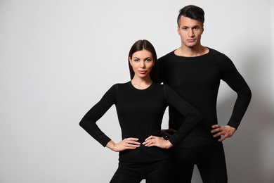 Photo of Couple wearing thermal underwear on light grey background. Space for text