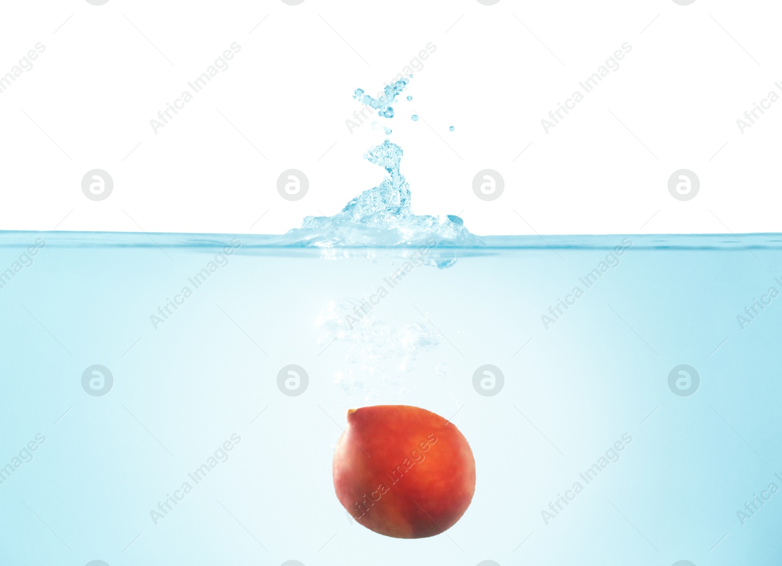 Photo of Peach falling down into clear water against white background