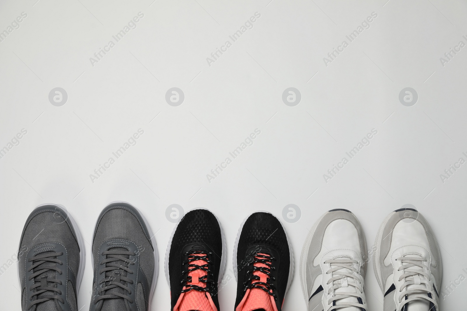 Photo of Different stylish sport shoes on white background, flat lay. Space for text