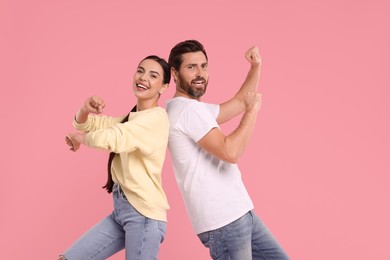 Photo of Happy couple dancing together on pink background