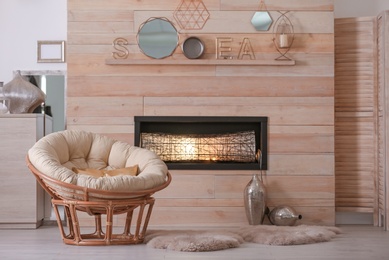 Photo of Cozy living room interior with comfortable papasan chair and decorative fireplace