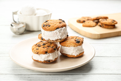 Photo of Sweet delicious ice cream cookie sandwiches on white wooden table