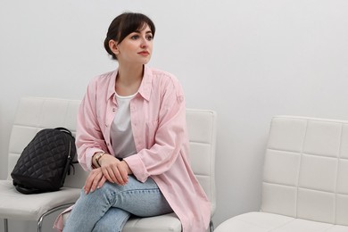 Woman sitting on chair and waiting for job interview indoors