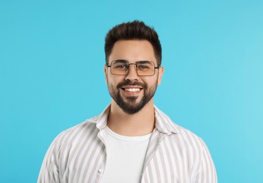 Handsome man wearing glasses on turquoise background