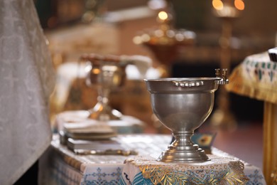 Photo of Silver vessel with holy water on stand in church. Baptism ceremony