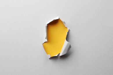 Hole in white paper on yellow background