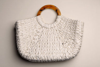 Stylish knitted woman's bag on beige background, top view