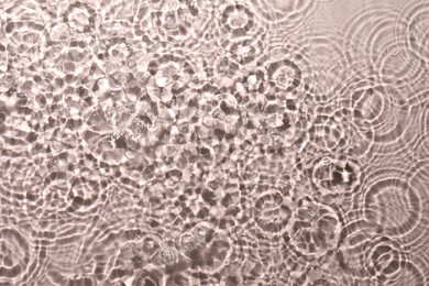 Photo of Rippled surface of clear water on beige background, top view