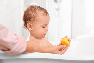 Photo of Mother with her little baby in bathroom