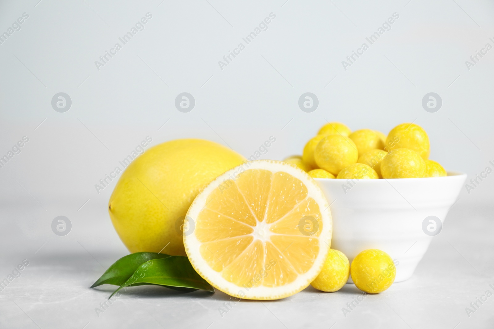 Photo of Composition with lemon drops on grey marble table