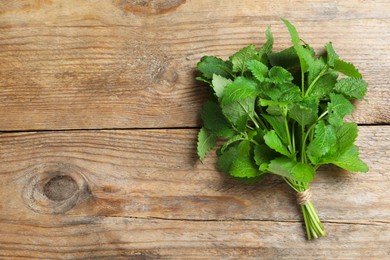 Fresh lemon balm on wooden table, top view. Space for text